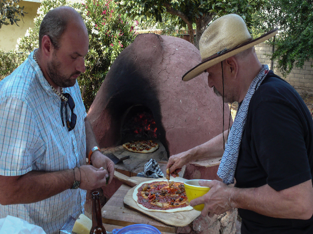 Ben's son Paolo (a restaurant executive chef in Seattle) assists Ben with cob oven pizza-making. Photo: Richard Shirley